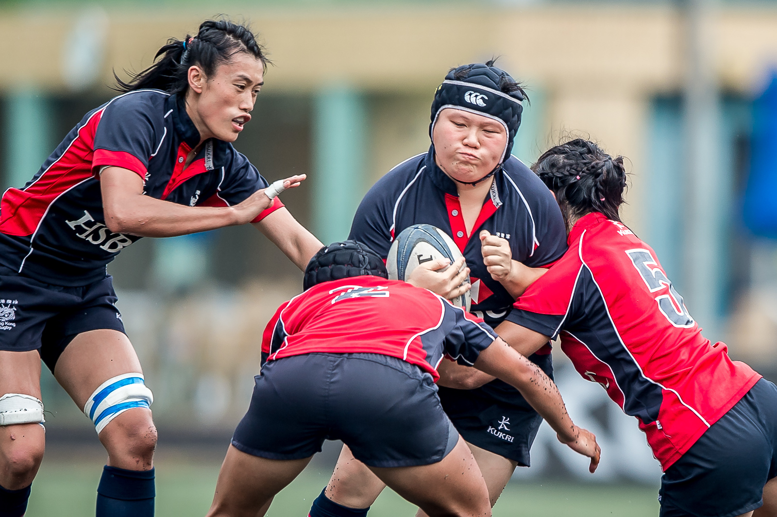 Hong Kong prop Lee Ka-shun carries the ball with support from captain Chow Mei-nam